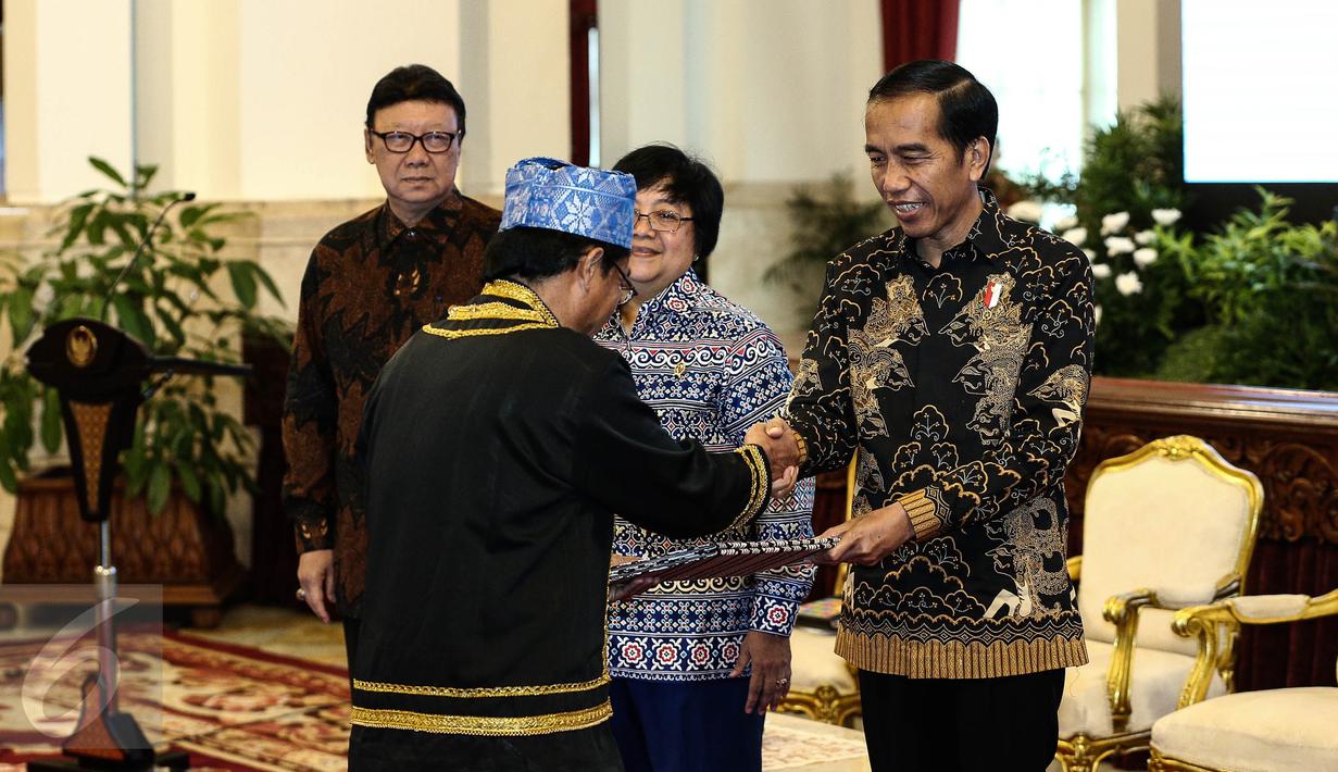 Presiden Joko Widodo menyerahkan surat keputusan pengakuan  Hutan Adat kepada perwakilan pemangku hutan adat saat pencanangan pengakuan hutan adat di Istana Negara, Jakarta, Jumat (30/12). (Liputan6.com/Faizal Fanani)