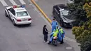Polisi yang mengenakan alat pelindung diri terlihat di jalan saat lockdown tahap kedua akibat COVID-19 di Distrik Jing'an, Shanghai, China, Selasa (5/4/2022). (Hector RETAMAL/AFP)