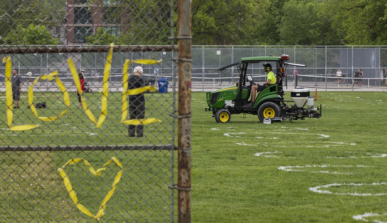 Pekerja menggambar lingkaran putih di Taman Trinity Bellwoods, Toronto, Kanada, Kamis (28/5/2020). Taman Trinity Bellwoods digambari lingkaran-lingkaran putih sebagai proyek uji coba untuk mendorong warga melakukan jaga jarak fisik (physical distancing) selama pandemi COVID-19. (Xinhua/Zou Zheng)