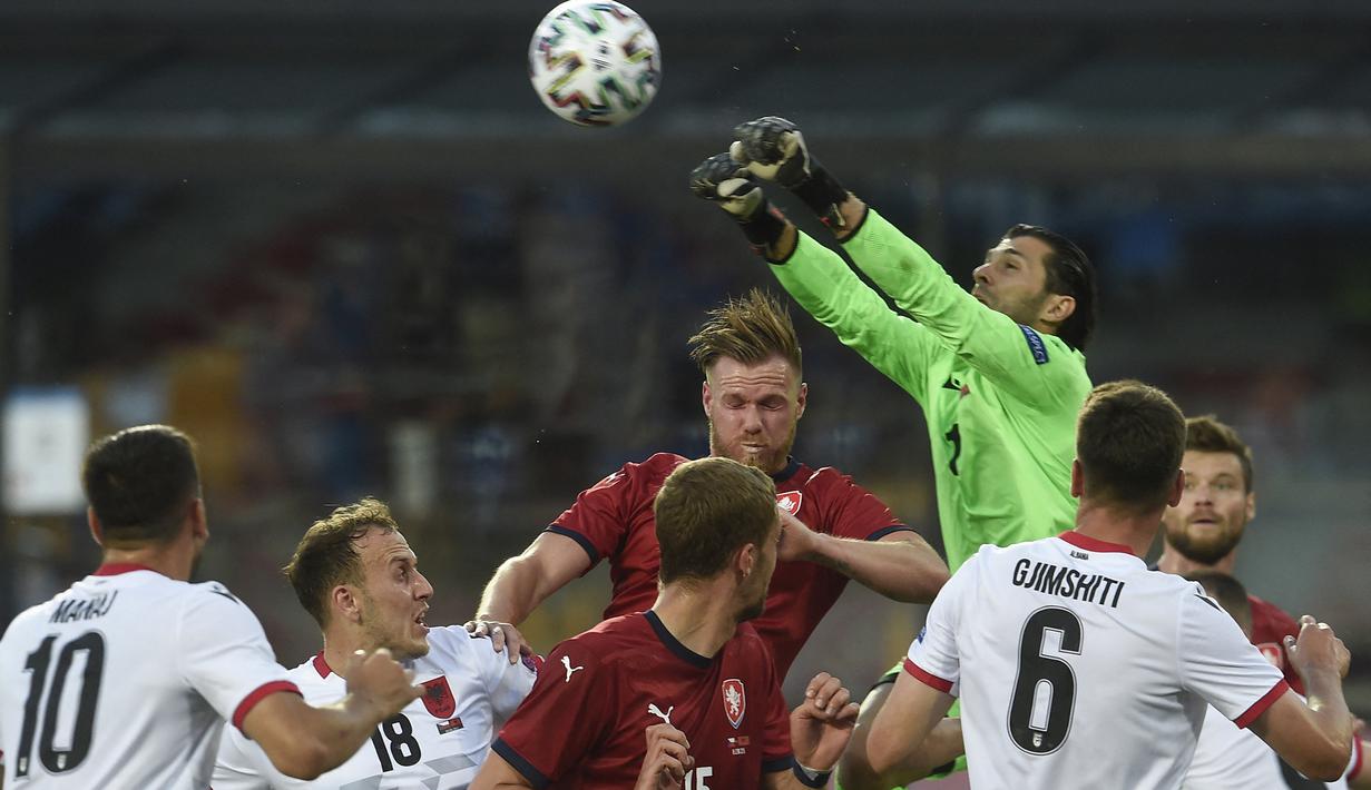 Kiper Albania, Gentian Selmani (atas) meninju bola dari ancaman pemain Republik Ceska dalam laga uji coba menjelang Euro 2020 di Praha, Republik Ceska, Selasa (8/6/2021). Albania kalah 1-3 dari Republik Ceska. (AFP/Michal Cizek)
