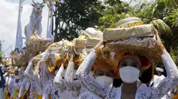 Perempuan Bali berbaris saat mereka membawa sesaji saat upacara Ngaben terhadap Ida Pedanda Nabe Gede Dwija Ngenjung di Denpasar, Jumat (8/10/2021). Upacara Ngaben itu sebagai penghormatan terakhir terhadap seorang pemuka agama Hindu di Bali. (AP Photo/Firdia Lisnawati)