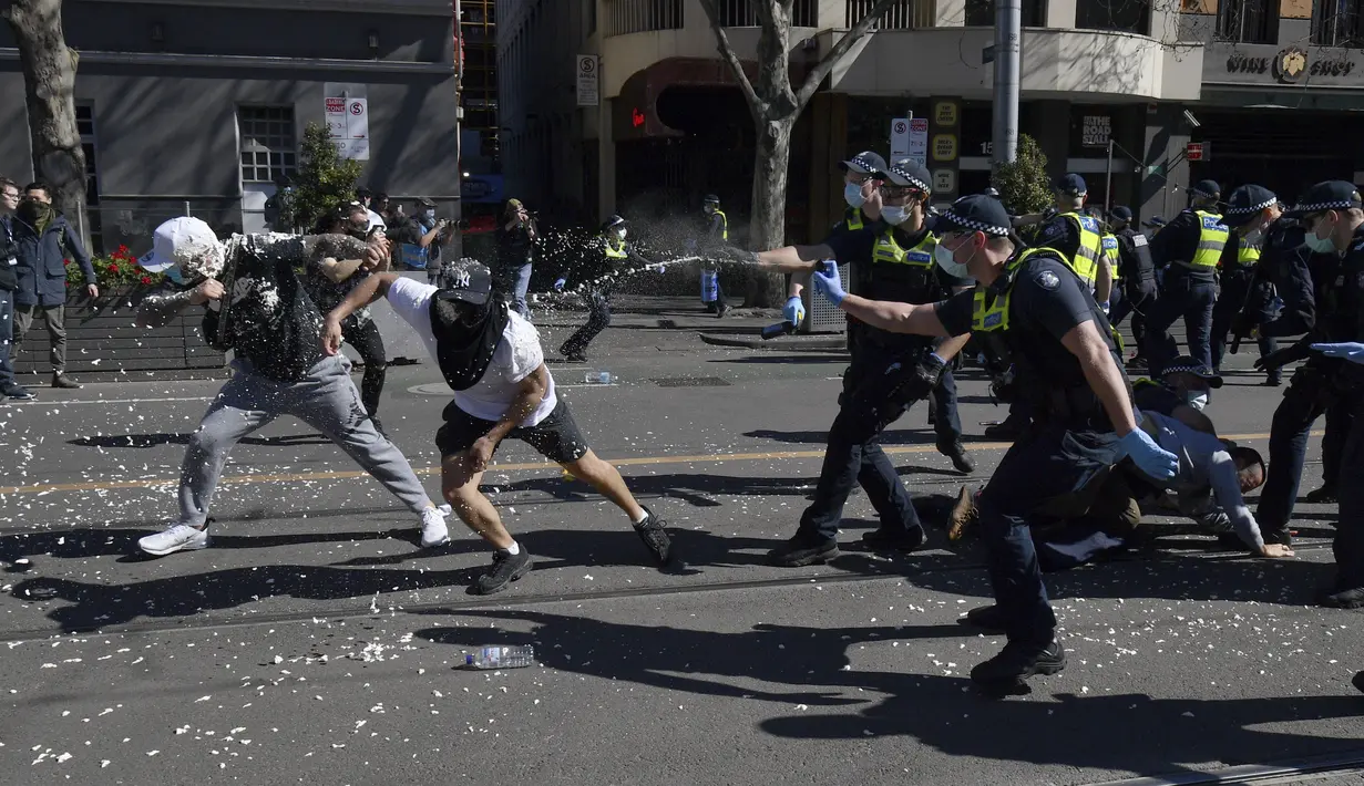 Polisi menggunakan semprotan merica pada pengunjuk rasa selama protes anti-lockdown di Melbourne, Australia, Sabtu (21/8/2021). Para pengunjuk rasa berunjuk rasa menentang pembatasan pemerintah yang ditempatkan dalam upaya mengurangi wabah COVID-19. (James Ross/AAP Image via AP)