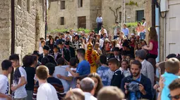 Seorang pria berkostum setan tiba untuk  tradisi El Salto del Colacho di desa Castrillo de Murcia, Spanyol, Minggu (3/6). Tradisi melompati bayi (El Colacho) ini bermakna untuk membersihkan bayi berusia hingga satu tahun dari roh jahat. (AFP/CESAR MANSO)