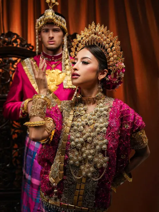 Aura mewah Jennifer semakin terpancar lewat tumpukan aksesori emas tradisional yang dikenakannya. Kalung bertumpuk berukuran besar, gelang khas adat, hingga pending emas membuat penampilannya terlihat begitu regal bak bangsawan Bugis-Makassar.  [@jennifercoppenreal20].