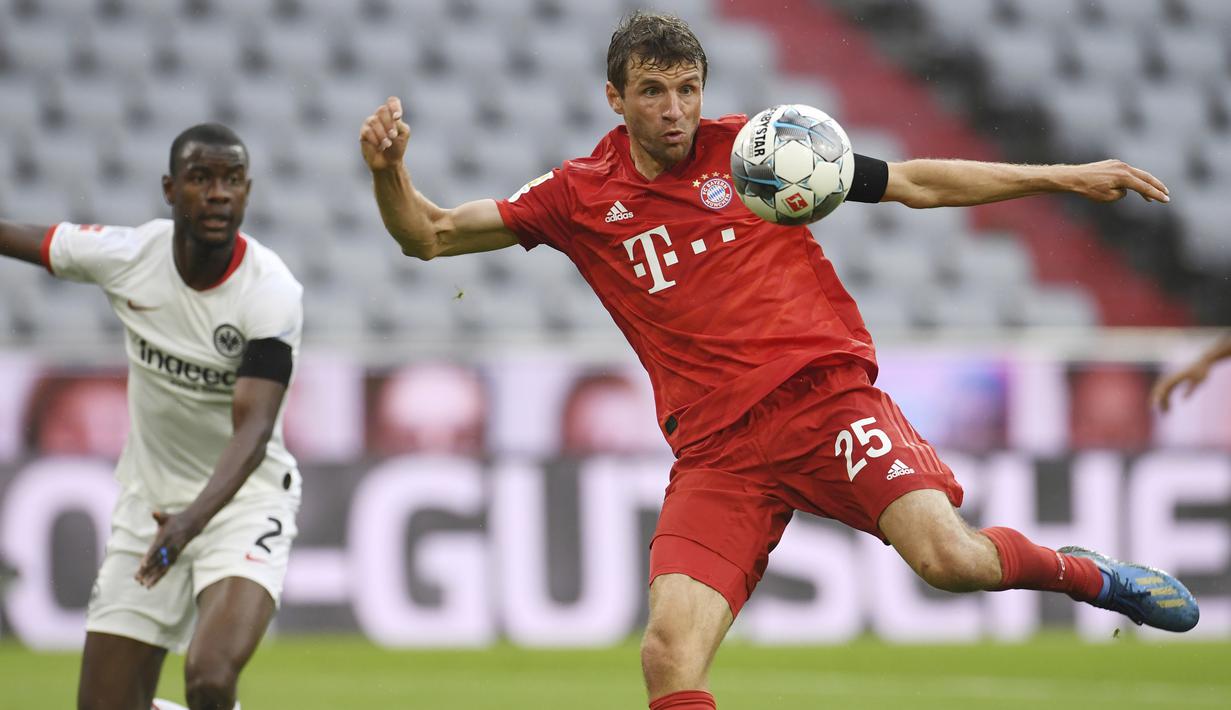 Pemain Bayern Munchen, Thomas Muller, mencetak gol ke gawang Eintracht Frankfurt pada laga Bundesliga di Allianz Arena, Minggu (24/5/2020). Bayern Munchen menang 5-2 atas Eintracht Frankfurt. (AP/Andreas Gebert)