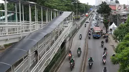 Pengendara motor dan mobil melintasi jalur bus Transjakarta di kawasan Pasar Rumput, Jakarta, Rabu (20/2). Sekitar 510 CCTV akan dipasang di 225 halte Transjakarta di Ibu Kota untuk menerapkan tilang online atau E-Tilang. (Liputan6.com/Immanuel Antonius)