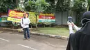 Seorang pria berfoto di depan karangan bunga untuk Ketua DPR, Setya Novanto di RSCM Kencana, Jakarta, Minggu (19/11). Sebelumnya, Novanto dirawat di Rumah Sakit Medika Permata Hijau setelah mengalami kecelakaan lalu lintas. (Liputan6.com/Herman Zakharia)