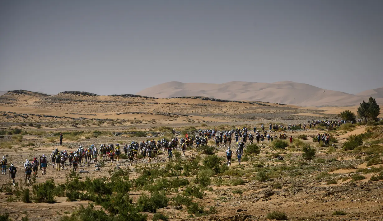 Para peserta bersaing dalam lomba lari Marathon des Sables ke-34 tahap kedua di Gurun Sahara, Maroko, Senin (8/4). Maraton ini menempuh perjalanan 250 kilometer dengan waktu sekitar enam hari. (JEAN-PHILIPPE KSIAZEK/AFP)
