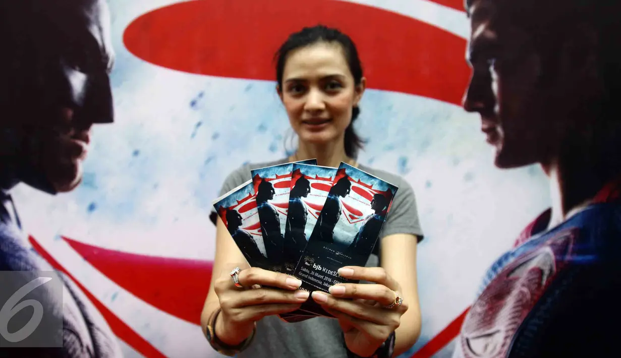 Seorang wanita memperlihatkan brosur nonton bareng Batman Vs Superman : Dawn of Justice di bioskop CGV Blitz Grand Indonesia Jakarta, Sabtu (26/3). Acara nonton bareng ini disponsori oleh Bank Jabar Banten (BJB). (Liputan6.com/Angga Yuniar)