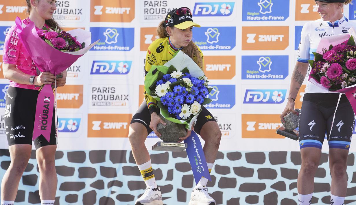 Pembalap Team Visma-Lease, Pauline Ferrand-Prevot berusaha menjunjung trofi kemenangan Paris Roubaix Femmes 2025 pada Sabtu (12/04/2025) waktu setempat. Perlombaan tersebut menempuh 148,5 km dari Denain hingga Roubaix, Prancis. (AP Photo/Thibault Camus)
