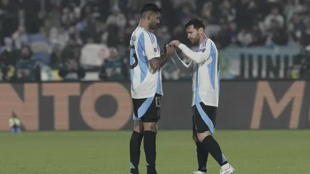 Cristian Romero dari Argentina menyerahkan ban kapten kepada Lionel Messi