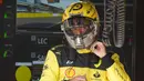 Pebalap mereka, Charles Leclerc dan Carlos Sainz juga tampak menggunakan baju balap dan helm yang berwarna kuning dalam sesi latihan bebas kemarin. (AP/Luca Bruno)