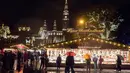 Wisawatan menerobos hujan saat mengunjungi pasar Natal di luar City Hall, Wina pada 26 November 2018. Christkindlmarkt menjadi ciri khas Natal dan musim dingin di Austria dan juga Jerman yang sudah sejak pertengahan tahun 1310. (JOE KLAMAR / AFP)