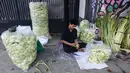 Kulit ketupat tersebut dipasarkan dengan harga Rp1.000 hingga Rp1.500 per buah, tergantung ukuran dan kualitas anyaman. Tampak dalam foto, pedagang menyelesaikan produksi kulit ketupat lebaran di Pasar Pondok Labu, Jakarta, Rabu (18/3/2026). (merdeka.com/Arie Basuki)