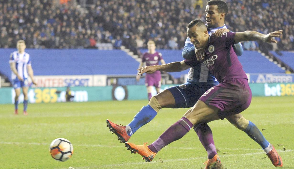 Aksi pemain Manchester City, Danilo (kanan) berusaha melewati adangan pemain Wigan, Nathan Byrne pada laga babak kelima Piala FA di DW Stadium, Wigan, (19/2/2018). Manchester City kalah 0-1.  (AP/Rui Vieira)