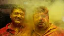 Dua orang pria dengan wajah penuh bubuk berwarna saat mengikuti Festival Holi di Prayagraj, India, Selasa (10/3/2020). Festival Holi menandai datangnya musim semi di India. (AP Photo/Rajesh Kumar Singh)