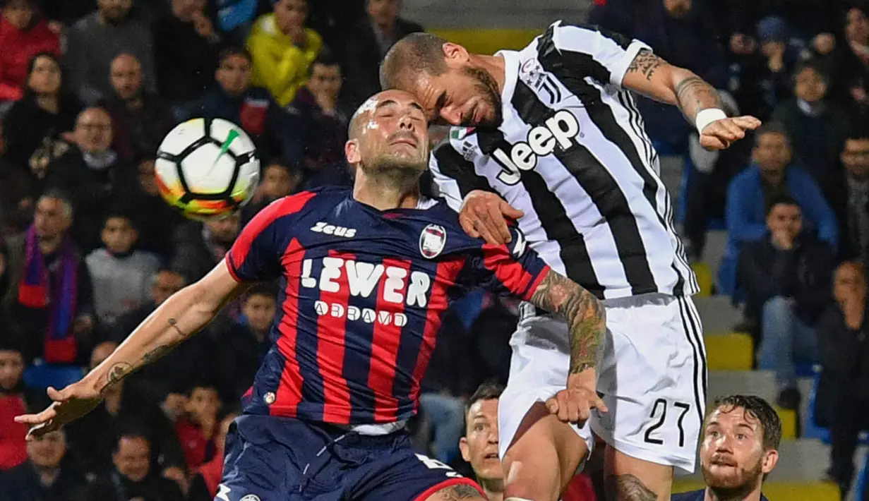 Gelandang Juventus, Stefano Sturaro, duel udara dengan bek Crotone, Bruno Martella, pada laga Serie A di Stadion Ezio Scida, Kamis (19/4/2018). Juventus ditahan imbang 1-1 oleh Crotone. (AFP/Giovanni Isolino)