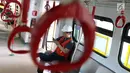 Seorang petugas berada di gerbong kereta Light Rail Transit (LRT) ketika melakukan ujicoba di Kelapa Gading, Jakarta, Kamis (14/6). Kereta LRT diuji coba sejauh 1,1 kilometer dengan kecepatan 80 km per jam. (Liputan6.com/Immanuel Antonius)