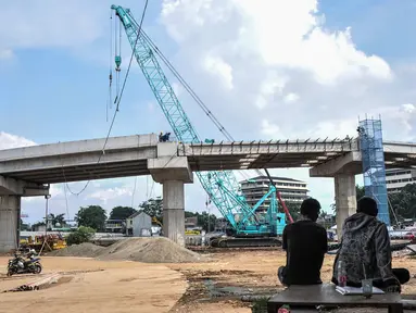 Warga menyaksikan proyek pembangunan Jalan Tol Bekasi-Cawang-Kampung Melayu (Becakayu) Seksi 1, D.I Panjaitan, Jakarta, Kamis (18/11/2021). BPJT mendata hingga akhir kuartal III/2021 perkembangan pembangunan Tol Becakayu Seksi 1 saat ini mencapai 95,54 persen. (merdeka.com/Iqbal S Nugroho)