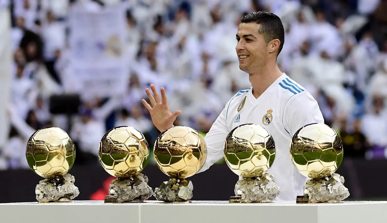 Bintang Real Madrid, Cristiano Ronaldo, berpose dengan kelima trofi Ballon d'Or di Stadion Santiago Bernabeu, Sabtu (9/12/2017). Cristiano Ronaldo meraih Ballon d'Or 2017 setelah unggul dari Lionel Messi dan Neymar. (AFP/Pierre-Philippe Marcou)