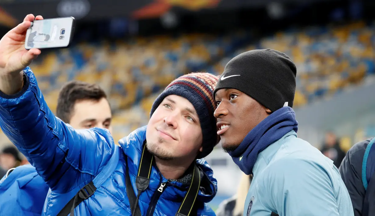 Seorang penggemar berselfie dengan penyerang Chelsea, Callum Hudson-Odoi selama sesi pelatihan di NSC Olympiyskiy, Kiev, Ukraina (13/3). Chelsea akan bertanding melawan Dynamo Kiev pada leg kedua babak 16 besar Liga Europa. (Reuters/Valentyn Ogirenko)