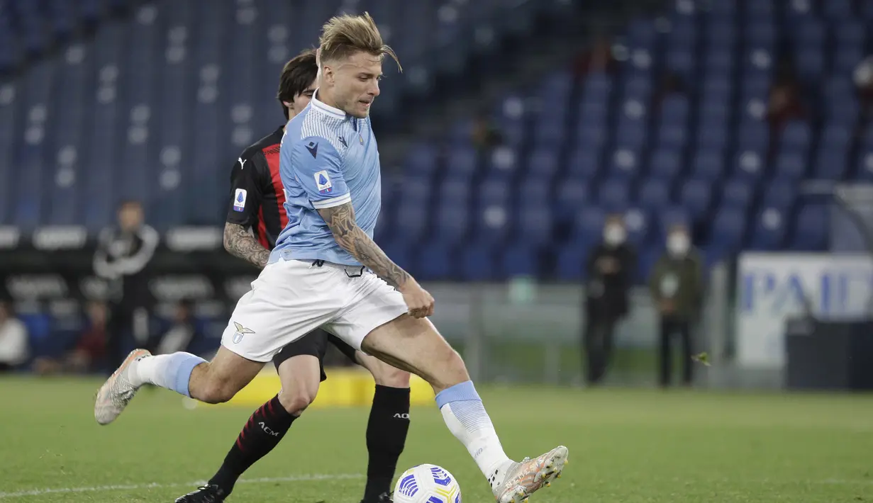 Striker Lazio, Ciro Immobile melepaskan tendangan yang berbuah gol ketiga timnya ke gawang AC Milan dalam laga lanjutan Liga Italia 2020/2021 pekan ke-33 di Olimpico Stadium, Roma, Senin (26/4/2021). Lazio menang 3-0 atas AC Milan. (AP/Gregorio Borgia)