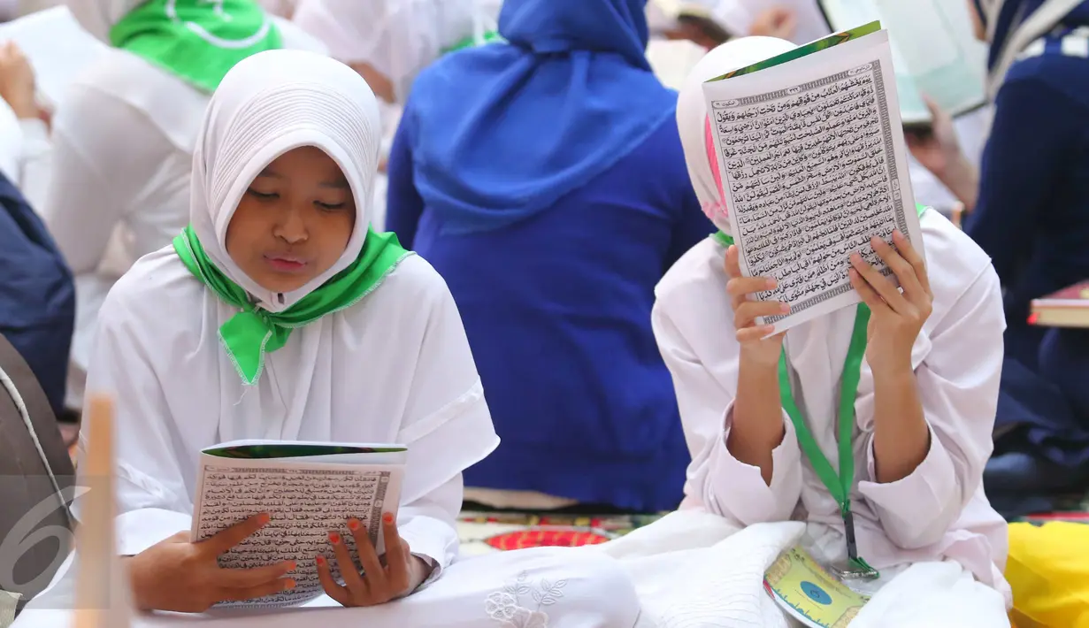 Dua orang santri membaca Al Quran di Gedung Pertamina, Jakarta, Kamis (23/6). Dalam rangka peringatan Nuzulul Quran, Pertamina bersama 27.218 anak yatim se-Jakarta membaca kitab suci Al Quran hingga khatam. (Liputan6.com/Angga Yuniar)