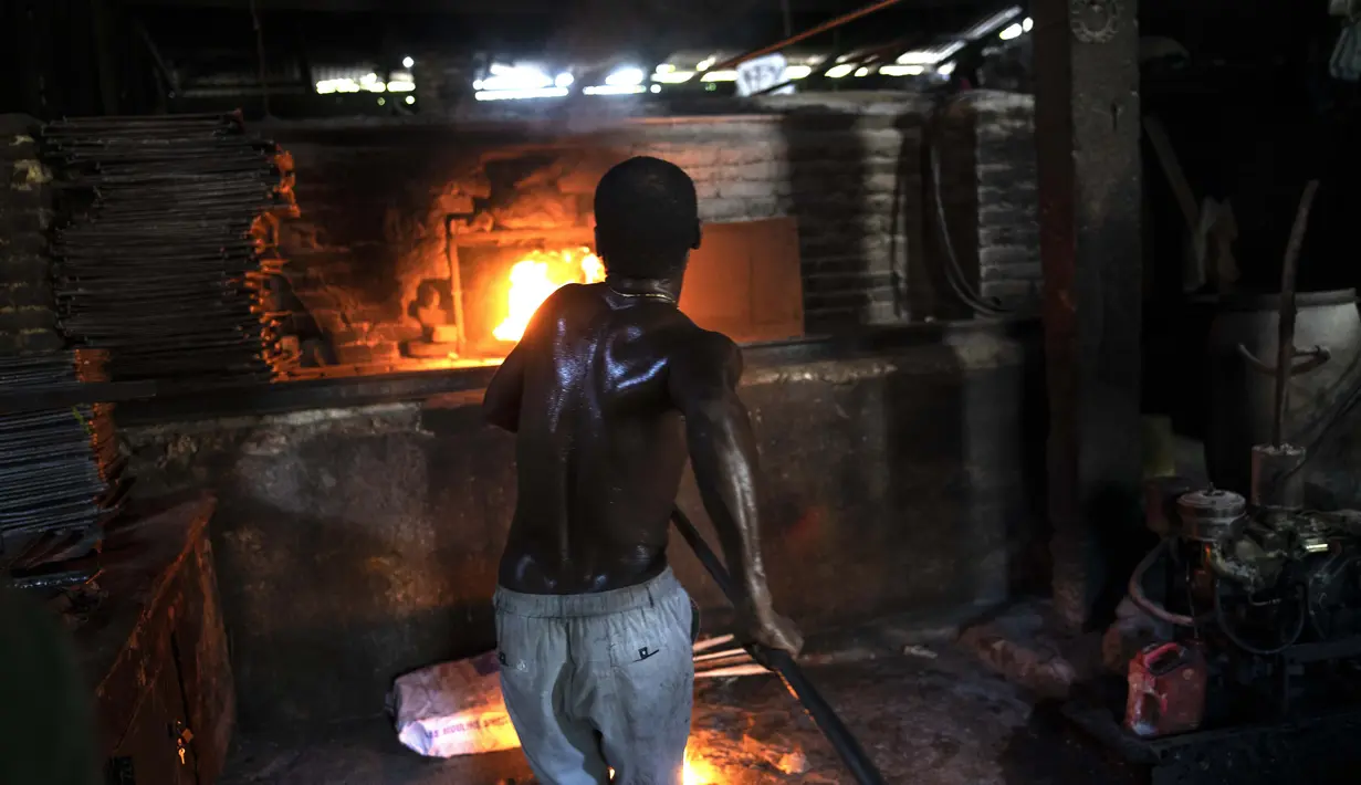 Seorang pria menyalakan oven kayu untuk membuat roti di toko roti Bongu di lingkungan Bel Air di Port-au-Prince, Haiti, Senin (27/9/2021).  (AP Photo/Rodrigo Abd)