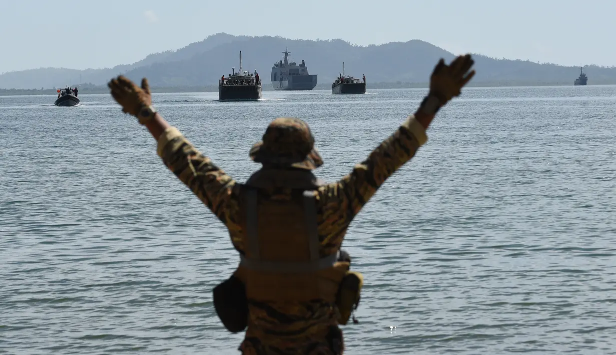 Anggota NAVSOG memberi sinyal ke kapal Filipina yang ditumpangi oleh marinir Filipina-AS saat simulasi bencana dan keamanan dalam latihan militer gabungan di Kota Casiguran, provinsi Aurora (15/5). (AFP Photo/Ted Aljibe)