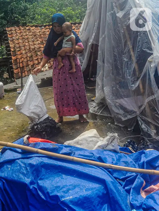 Warga beraktivitas pada tenda darurat yang dibangun di atas rumah pasca banjir melanda kawasan Pejaten Timur, Jakarta Selatan, Senin (8/1/2024). (merdeka.com/Arie Basuki)