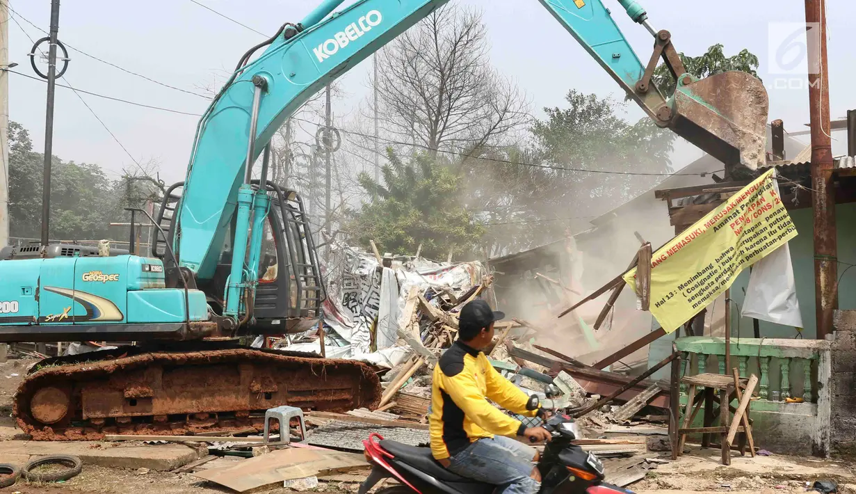 Alat berat meratakan rumah saat proses eksekusi lahan untuk proyek jalan Tol Cijago di kawasan Kukusan, Depok, Rabu (12/12). PN Depok kembali mengeksekusi 20 bidang lahan terkait proyek jalan tol Cijago Seksi II. (Liputan6.com/Immanuel Antonius)