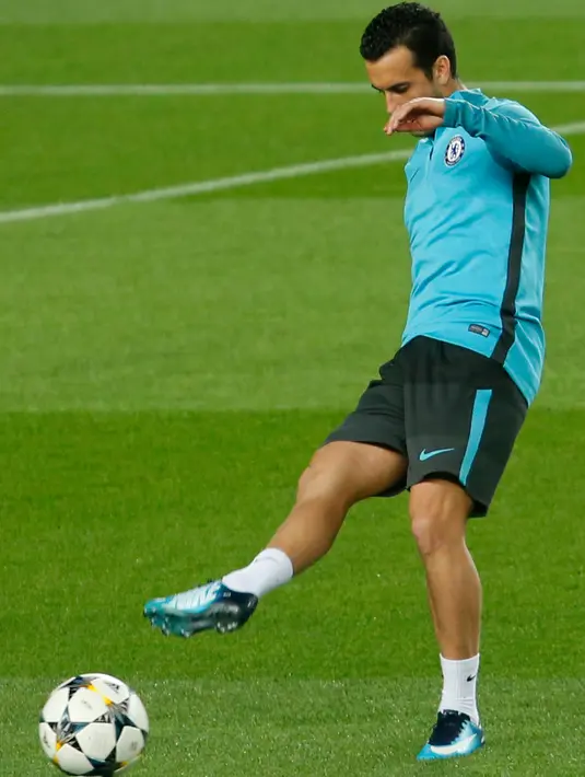 Gelandang Chelsea, Pedro menendang bola saat latihan tim di stadion Camp Nou di Barcelona (13/3). Pada leg pertama Chelsea bermain imbang 1-1 dengan Barcelona di Stadion Stamford Brigde, Inggris. (AFP Photo/Pau Barrena)