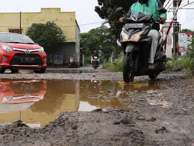 Kendaraan menghindari kubangan pada jalan yang rusak di Jalan Pertamina, Kemiri Muka, Depok, Jawa Barat, Selasa (5/3). Jalan rusak yang telah berlangsung bertahun-tahun tersebut tak kunjung diperbaiki. (Liputan6.com/Immanuel Antonius)