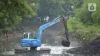 Pekerja mengoperasikan alat berat excavator untuk mengangkat material endapan lumpur di kanal sungai perkantoran Kuningan Jakarta, Rabu (17/2/2021). Pengerukan dilakukan untuk memperlancar aliran air agar tidak terjadi pendangkalan yang mengakibatkan genangan air. (merdeka.com/Imam Buhori)