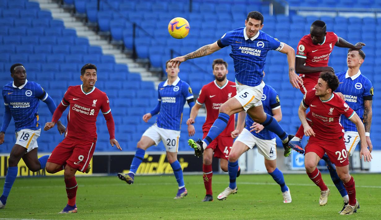 Bek Brighton, Lewis Dunk, berusaha menyundul bola saat menghadapi Liverpool pada laga lanjutan Liga Inggris di Stadion American Express, Sabtu (28/11/2020) malam WIB. Liverpool bermain imbang 1-1 menghadapi Brighton. (AFP/Mike Hewitt/pool)