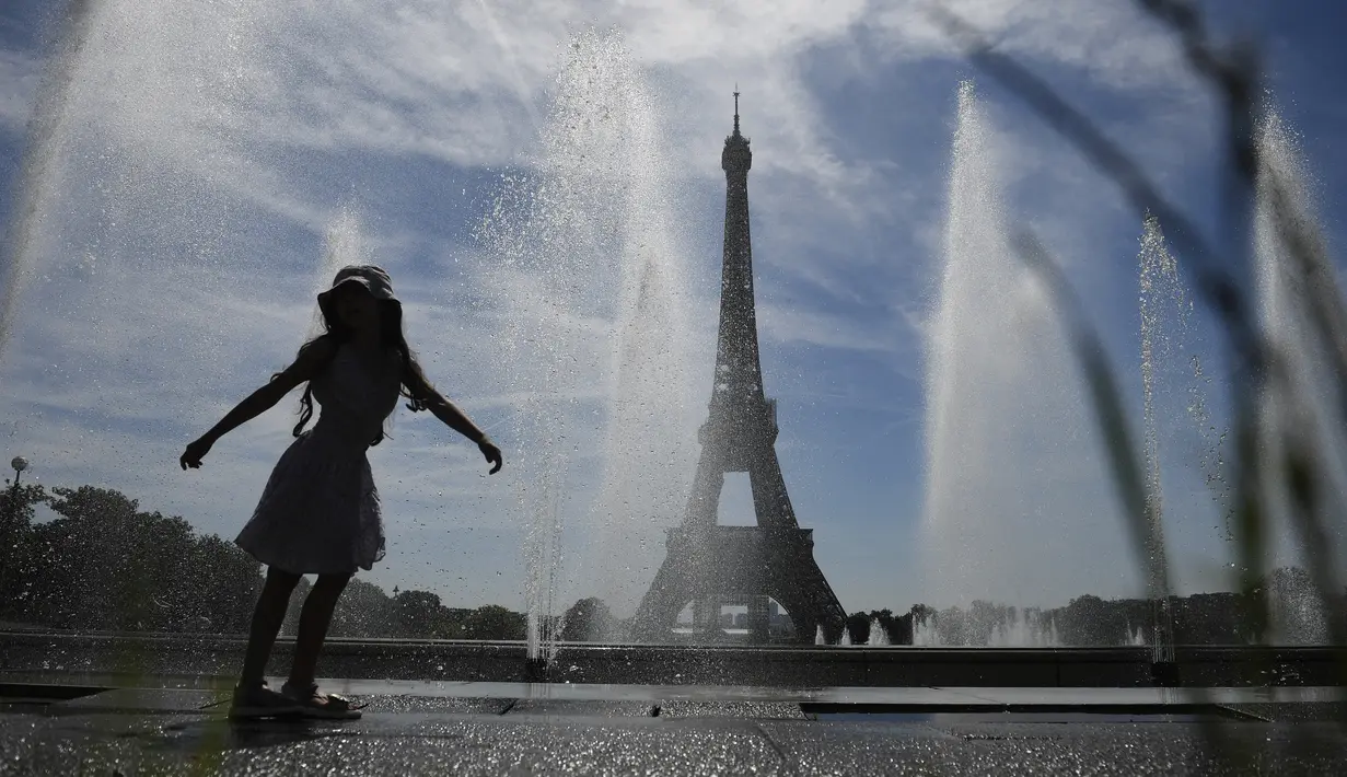 Seorang gadis muda mendinginkan diri di dekat air mancur Trocadero, di tengah suhu tinggi di Paris, Kamis (16/6/2022). Prancis akan mengalami suhu yang memecahkan rekor mendekati 40 derajat Celcius pada Juni, karena gelombang panas dini yang diperkirakan akan melanda sebagian besar negara itu.
(JULIEN DE ROSA / AFP)