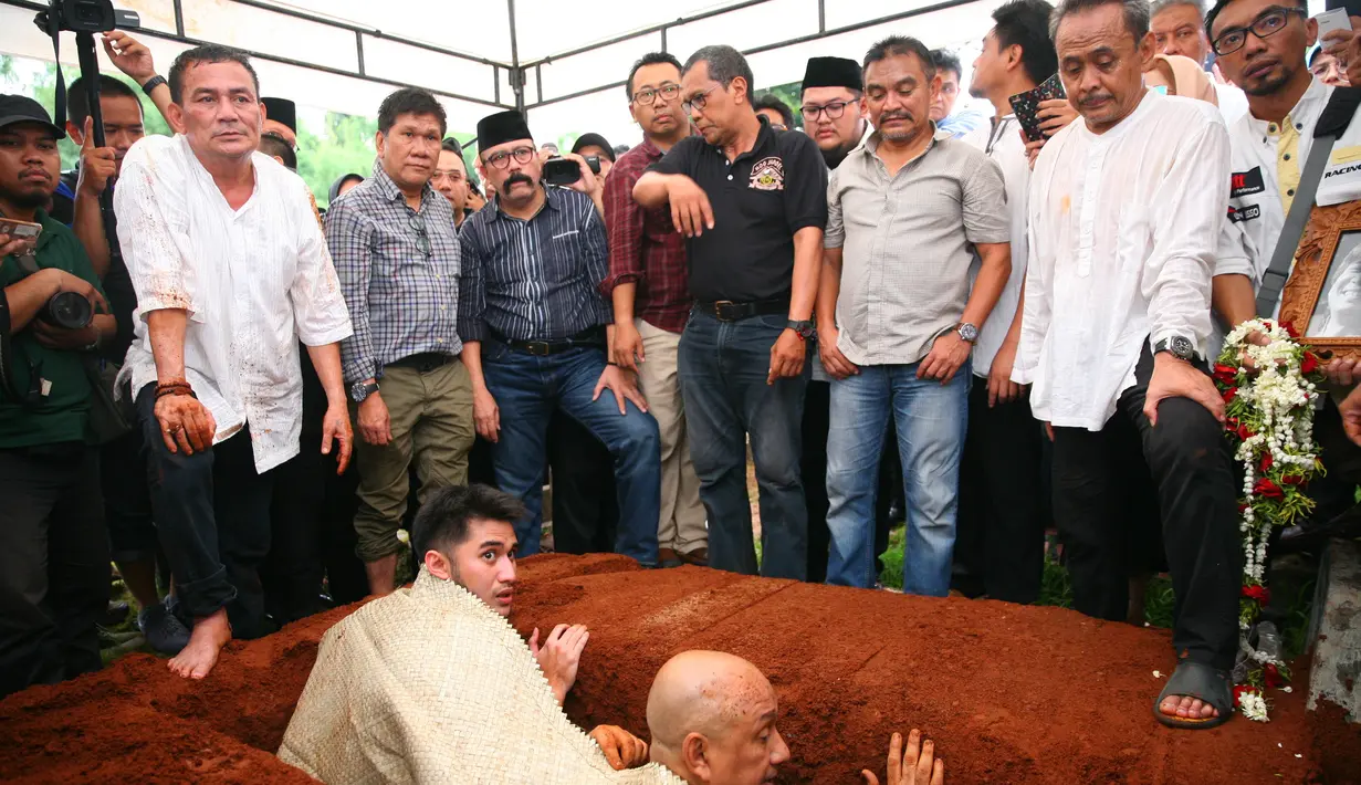 Isak tangis masih terdengar saat jenazah akan dimasukkan ke liang lahat. Sebelumnya, pihak keluarga dan Menteri Agama memberikan sambutannya. (Nurwahyunan/Bintang.com)