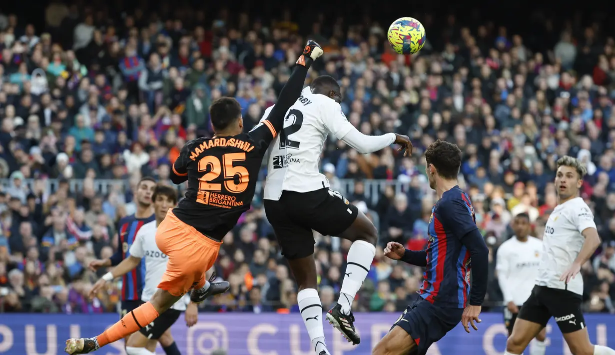Kiper Valencia Giorgi Mamardashvili menyelamatkan bola saat bertanding melawan Barcelona pada pertandingan lanjutan La Liga Spanyol di stadion Camp Nou, Spanyol, Minggu (5/3/2023). Barcelona menang tipis atas Valencia dengan skor 1-0. (AP Photo/Joan Monfort)