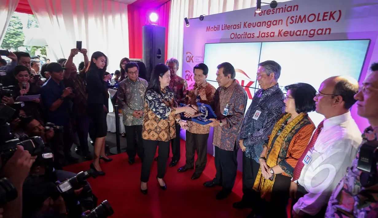 Menko PMK, Puan Maharani memberikan cendramata saat meluncurkan mobil literasi keuangan (Si Molek) di Kantor Menko PMK, Jakarta (12/5/2015). 21 unit Si Molek diluncurkan untuk menambah 20 mobil yang sudah ada sebelumnya. (Liputan6.com/Faizal Fanani)