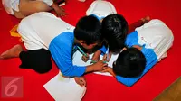 Sejumlah anak yatim ketika menulis surat untuk Presiden Jokowi di TMII, Jakarta, Minggu (19/6). Standardpen mengajak anak Indonesia kembali menulis dengan tangan melalui Gerakan Ayo Menulis dan membagikan Satu Juta Bolpoin. (Liputan6.com/Yoppy Renato)