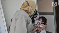 Dokter menenangkan balita usai diberikan imunisasi di Puskesmas Kecamatan Jatinegara, Jakarta, Kamis (26/11/2020). (merdeka.com/Iqbal S. Nugroho)