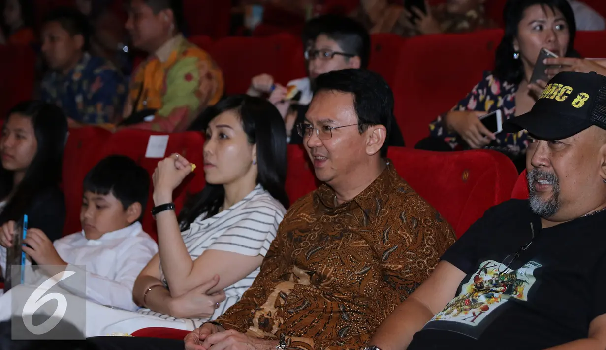 Gubernur DKI Jakarta Basuki T Purnama alias Ahok bersama istri saat menyaksikan film Comic 8 di Djakarta Theatre, Jakarta, Jumat (18/3). Film yang disutradarai Anggy Umbara ini meraih penghargaan Poster Film Terbaik. (Liputan6.com/Herman Zakharia)