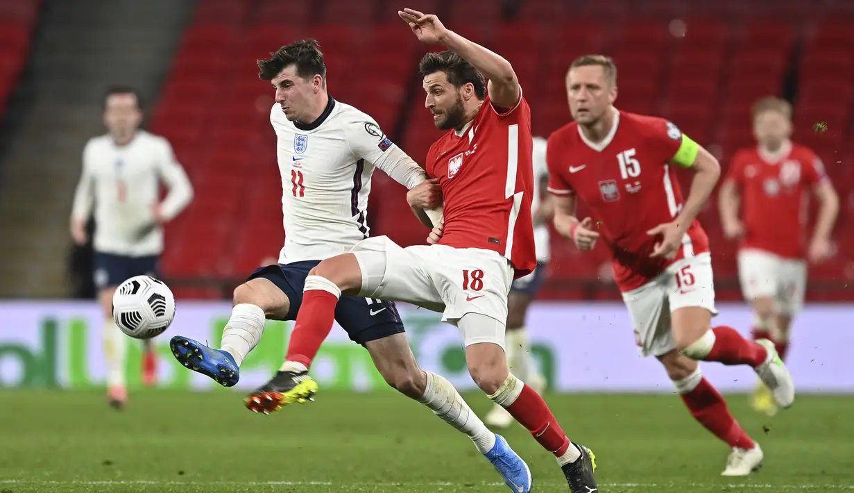 Gelandang Inggris, Mason Mount (kiri) berebut bola dengan bek Polandia, Bartosz Bereszynski dalam laga lanjutan Kualifikasi Piala Dunia 2022 Zona Eropa Grup I di Wembley Stadium, London, Rabu (31/3/2021). Inggris menang 2-1 atas Polandia. (AP/Andy Rain)