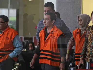 Tersangka anggota DPRD Malang Wiwik Hendri Astuti, M Zainudin dan Suprapto mengenakan rompi tahanan usai menjalani pemeriksaan di Gedung KPK, Jakarta, Rabu (28/3). 5 anggota DPRD Malang resmi ditahan atas dugaan suap APBD-P. (Liputan6.com/Herman Zakharia)