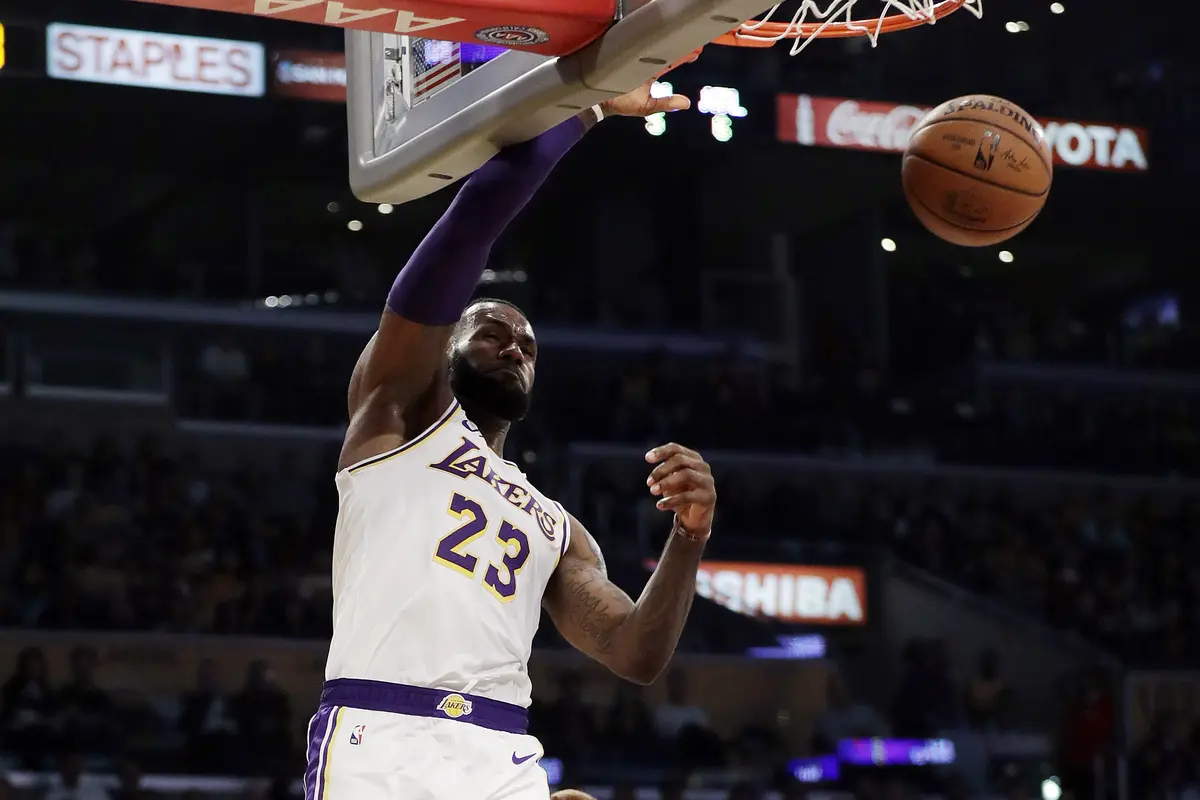 Aksi LeBron James melakukan dunk kala Lakers melawan Suns pada lanjutan NBA