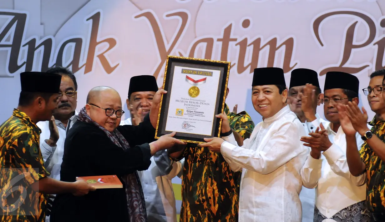 Ketua Umum Partai Golkar, Setya Novanto (kedua kanan) mengangkat penghargaan dari MURI jelang buka puasa AMPG bersama ribuan anak yatim piatu di Jakarta, Sabtu (18/6). Acara diikuti sekitar 26 ribu anak yatim piatu. (Liputan6.com/Helmi Fithriansyah)