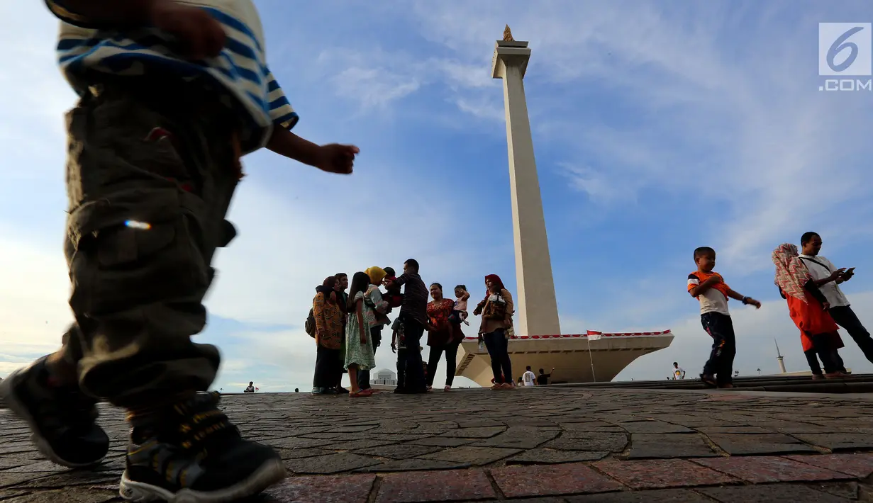 Pengunjung berwisata ke Monumen Nasional (Monas), Jakarta, Rabu (27/6). Mengisi waktu libur Idul Fitri, kawasan Monas menjadi pilihan alternatif untuk berlibur bersama sanak keluarga. (Liputan6.com/Johan Tallo)