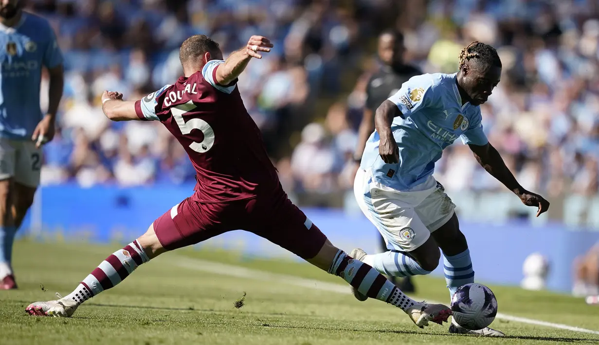 Gelandang Manchester City, Jeremy Doku (kanan) berusaha melewati adangan bek West Ham United, Vladimir Coufal pada laga pekan terakhir Liga Inggris 2023/2024 di Etihad Stadium, Manchester, Minggu (19/5/2024). (AP Photo/Dave Thompson)