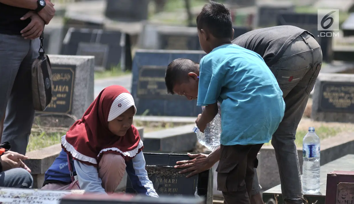 Kelompok anak-anak membersihkan salah satu makam di TPU Penggilingan, Pulogadung, Jakarta, Kamis (10/5). Tradisi ziarah jelang Ramadan menjadi berkah bagi anak-anak pembersih makam atau biasa dikenal 'Ngoret'. (Merdeka.com/Iqbal S. Nugroho)