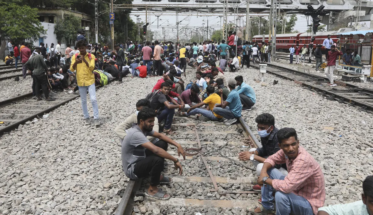 Para pengunjuk rasa duduk di rel kereta api di stasiun kereta api Secundrabad di Hyderabad, India, Jumat (17/6/2022). Unjuk rasa hari kedua berturut-turut pada hari Jumat menentang skema rekrutmen pemerintah jangka pendek yang baru untuk militer. (AP Photo/Mahesh Kumar A)